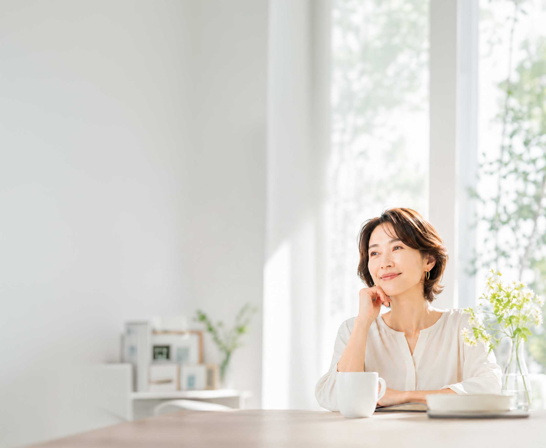 明るい窓辺でほほえむ大人の女性