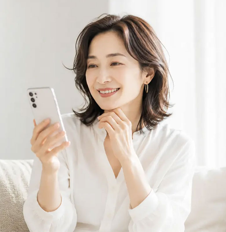 スマートフォンを見ながらほほえむ女性