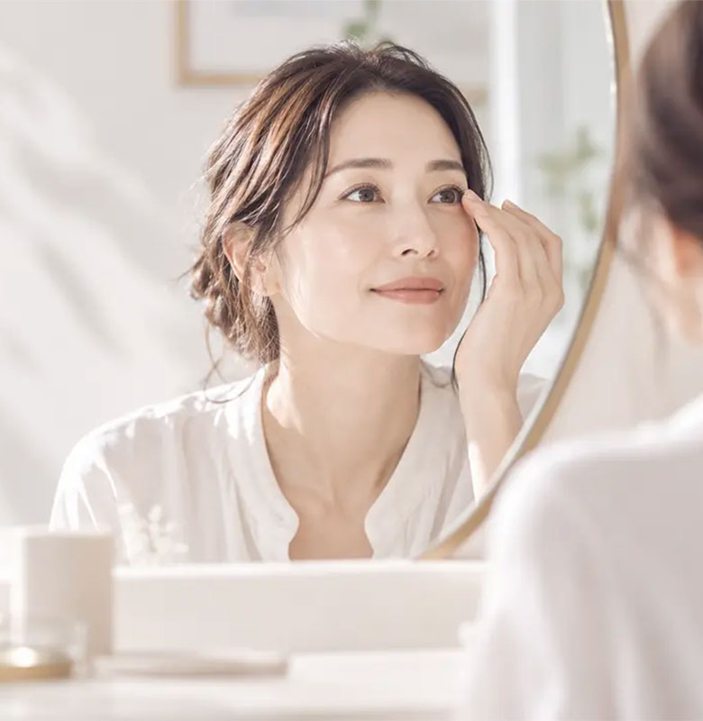 鏡を見ながらコンタクトレンズを装用する女性